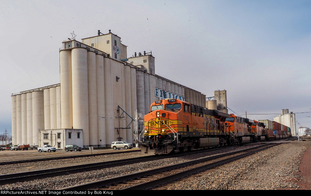 BNSF 7743 leads eastbound stacks past the grain elevators in Hereford, TX